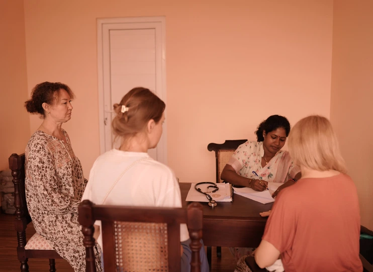 Guests meeting with an Ayurveda physician at a wooden table