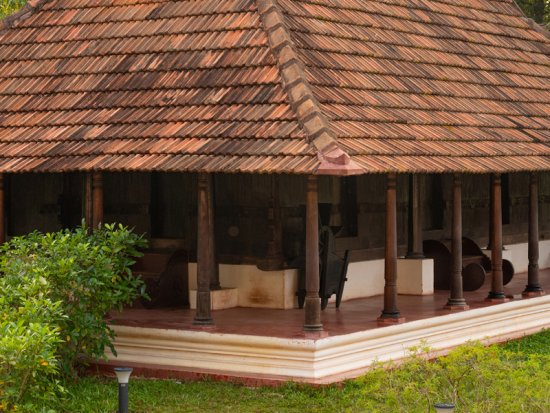 Sloped tiled roof and wooden pillared veranda of an ayurvedic treatment centre in Kerala