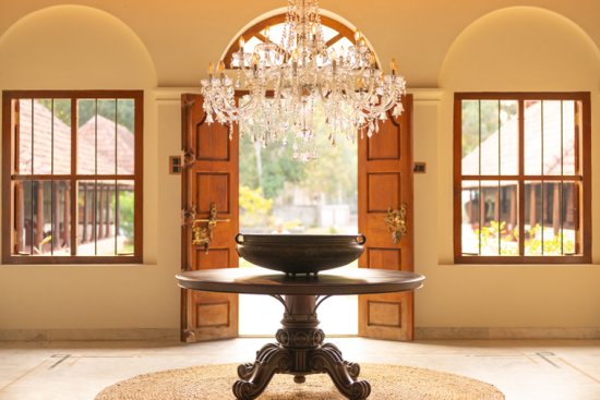  Elegant entrance hall with chandelier and antique brass urn at the best ayurveda resort in Alappuzha